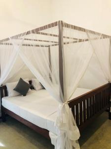 a bed with mosquito netting on it in a room at Jungle Restaurant and Villa in Unawatuna +70 photos