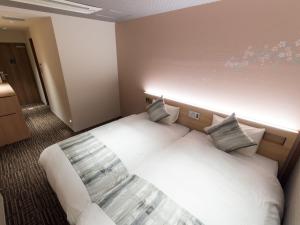 a bedroom with a white bed in a room at Stay SAKURA Kyoto Higashi Hongan-ji I in Kyoto