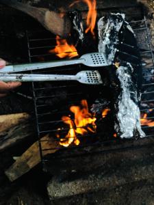 a grill with two tongs and fire in it at Jungle Restaurant and Villa in Unawatuna +112 photos