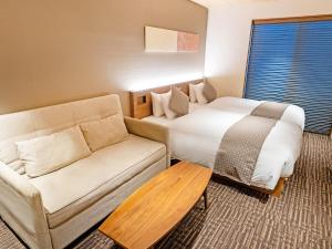 a hotel room with a bed and a couch at Stay SAKURA Kyoto Higashi Hongan-ji I in Kyoto