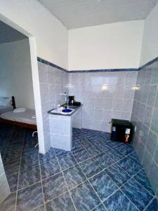 a bathroom with a tiled floor with a sink at La Mar Paraty Hospedaria 02 in Paraty
