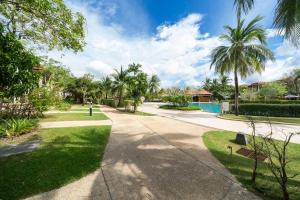 a walkway with palm trees and a swimming pool at Luxury 2 Bedrooms Villa Bangtao in Ban Pa Khlok
