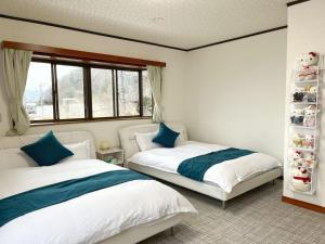 Postel nebo postele na pokoji v ubytování FujiAlpes 富士山を望む貸切宿 駅近 プロジェクター完備 最大13名