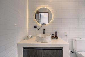 a white bathroom with a sink and a mirror at Spacious luxury Canggu villa 3BR crate cafe, beach 10min in Canggu +31 photos