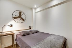 una camera da letto con un letto e un orologio sul muro di Le Vintage a Parigi
