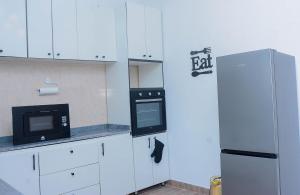 a kitchen with a refrigerator and a microwave at Stylish Haven, Luxe & Cozy in Mama +7 photos