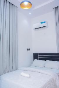 a bedroom with two beds with white sheets at Stylish Haven, Luxe & Cozy in Mama