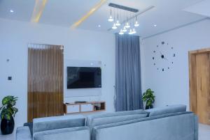 a living room with two blue couches and a tv at Stylish Haven, Luxe & Cozy in Mama