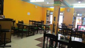 a dining room with tables and chairs and yellow walls at Sunshine Guest House & Restaurant in Dhunche