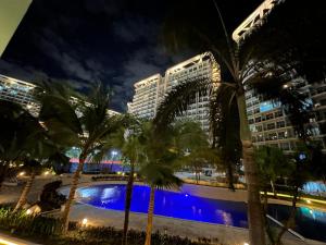 a group of palm trees and buildings at night at Azure Paranaque near Airport in Manila
