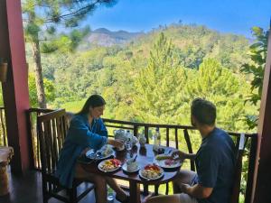 a man and a woman sitting at a table eating food at Turn View Resort Ella in Ella