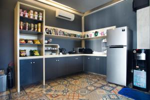 a kitchen with blue walls and a white refrigerator at M Boutique Hostel in Seminyak