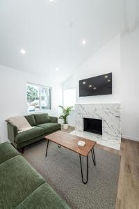 a living room with a couch and a fireplace at A Brand New Home In Los Angeles in Van Nuys County Court Heliport