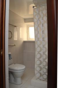 a bathroom with a toilet and a shower curtain at Hotel Premier in Golubitskaya