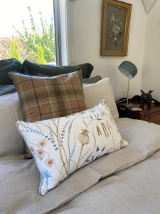 a pillow sitting on top of a couch with a window at Bannock Brae Vineyard Cottage in Cromwell