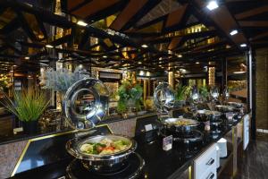 a buffet line with bowls of food on a counter at The Breton Hotel Media in Bangkok