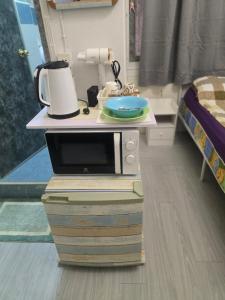 a microwave sitting on top of two books in a room at 103 Olan Place Apartment with fan and near SkyTrain and free Wi-Fi in Bangkok +6 photos