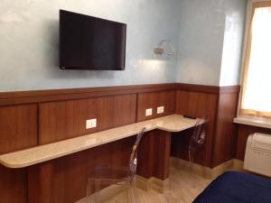 a room with a tv on a wall with a table at Residenza Matteucci in Rome