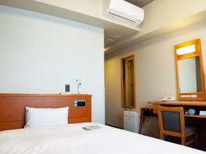 Postel nebo postele na pokoji v ubytování Hotel Route-Inn Niigata Kencho-minami