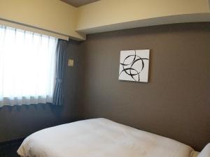 Postel nebo postele na pokoji v ubytování Hotel Route-Inn Niigata Kencho-minami
