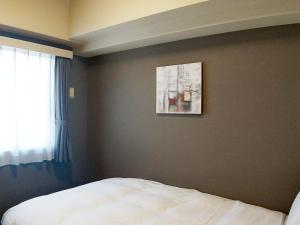 Postel nebo postele na pokoji v ubytování Hotel Route-Inn Niigata Kencho-minami