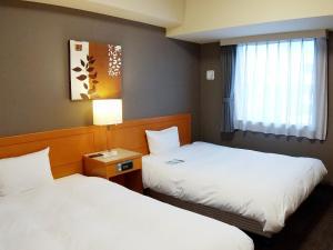 Postel nebo postele na pokoji v ubytování Hotel Route-Inn Niigata Kencho-minami