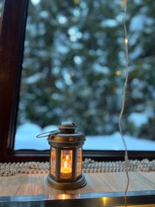 a candle sitting on a table in front of a window at Shgedi Mestia in Mestia