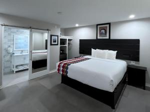 a bedroom with a large bed and a bathroom at Inn By the Bay Monterey in Monterey