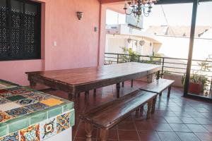 a table and benches in a room with windows at Hotel Tulum Centro, Party Hotel in Tulum