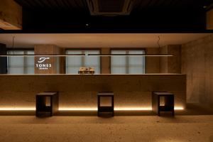 a bench in a building with a sign on it at TONES Osaka in Osaka