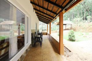 a porch of a house with a table and chairs at Hideaway Homestay By StayApart in Attigundi