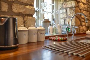 a counter with several coffee cups on a counter top at Orchard Cottage - Beautiful Home near Broadway! in Weston Subedge +129 photos