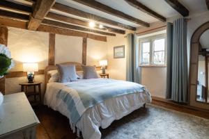 a bedroom with a bed in a room with wooden ceilings at Orchard Cottage - Beautiful Home near Broadway! in Weston Subedge