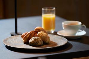 a plate of pastries and a cup of coffee and orange juice at TONES Osaka in Osaka