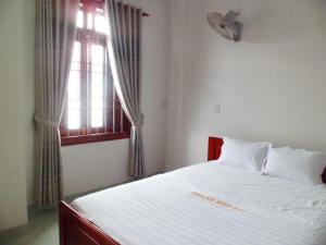 a bedroom with a white bed with a window at Thanh Hoa Hotel Nha Trang in Nha Trang