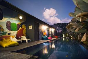 a house with a swimming pool with a mural at M Boutique Hostel in Seminyak