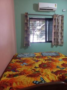 a bed with a colorful comforter in a bedroom at Malvan Beach Homestay in Malvan