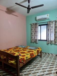 a bedroom with a bed and a ceiling fan at Malvan Beach Homestay in Malvan