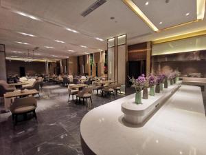un ristorante con tavoli, sedie e fiori viola di Lavande Hotel Wuxi East Railway Station a Wuxi
