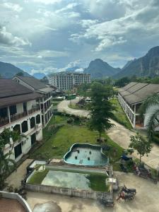 a resort with a swimming pool and mountains in the background at Thavisouk Hotel, Vang Vieng in Vang Vieng