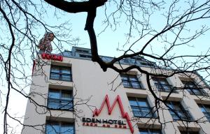 a sign on a building with a tree in front of it at Eden Hotel Früh am Dom in Cologne