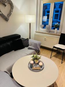 a living room with a white table and a couch at moderne Ferienwohnung am Stadtwald von Plauen in Plauen