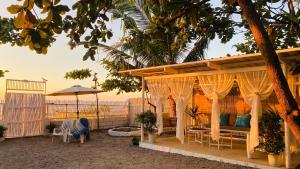 a house with a pergola on the beach at Tierra Bella-Exclusive Beachfront Villa at Elyu in Bauang