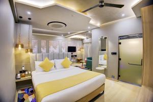 a bedroom with a large white bed with yellow pillows at Cozzet Mahad in Mahad