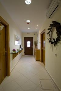 a hallway with a door and areath on the wall at Andria Suites in Andros