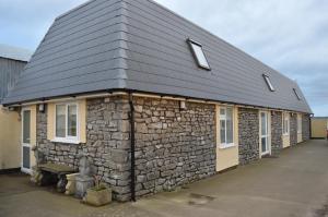 a stone building with a black roof at Worship Farm Accommodation in Redhill