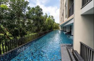 una piscina al lado de un edificio en 1 bedroom pool view in Bangtao, en Thalang