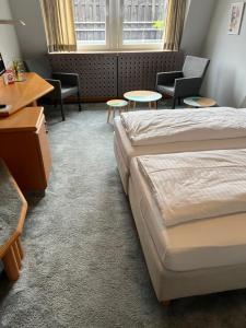 a hotel room with two beds and tables and chairs at Hotel Lachnerhof in Erlangen +11 photos