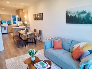 a living room with a blue couch and a table at Luxe & Bright Gem - Prime Location, Roof Deck, View in Seattle