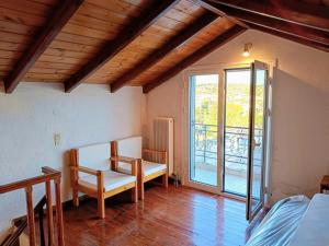 a room with a table and chairs and a balcony at Holiday House in Porto Heli